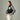 Elegant woman styling a structured black Braun Büffel handbag with a grey jacket in a clean studio shoot
